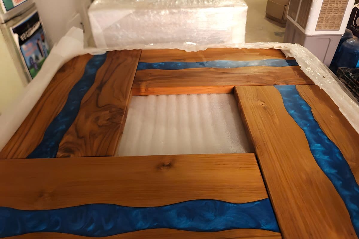 Finished large teak blue river boards laid out on a packed pallet