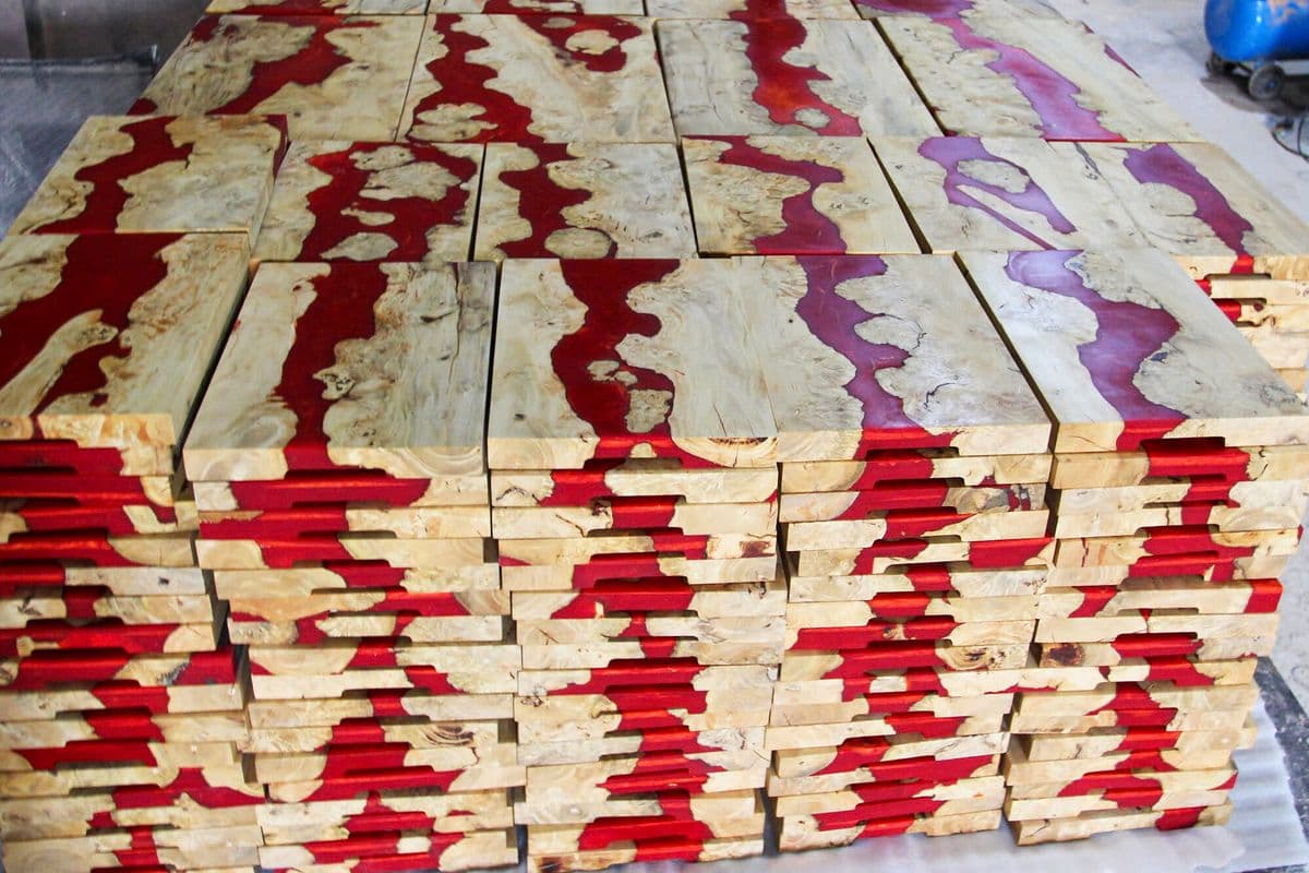 Stacks of finished red river coffee burl serving boards in the workshop
